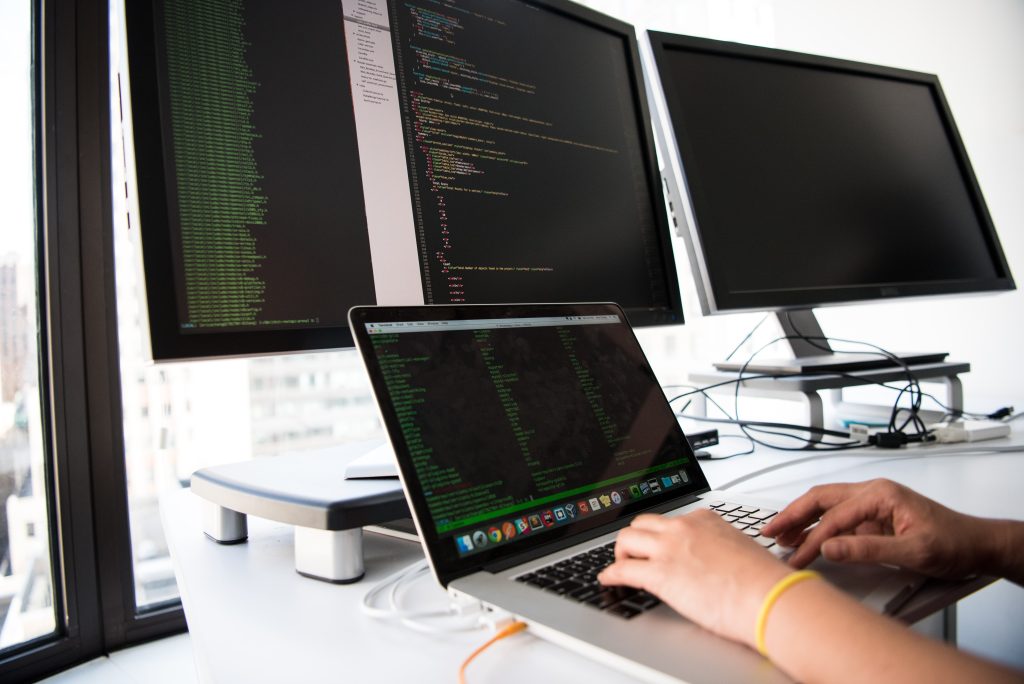 Manos en un portatil digitando codigo